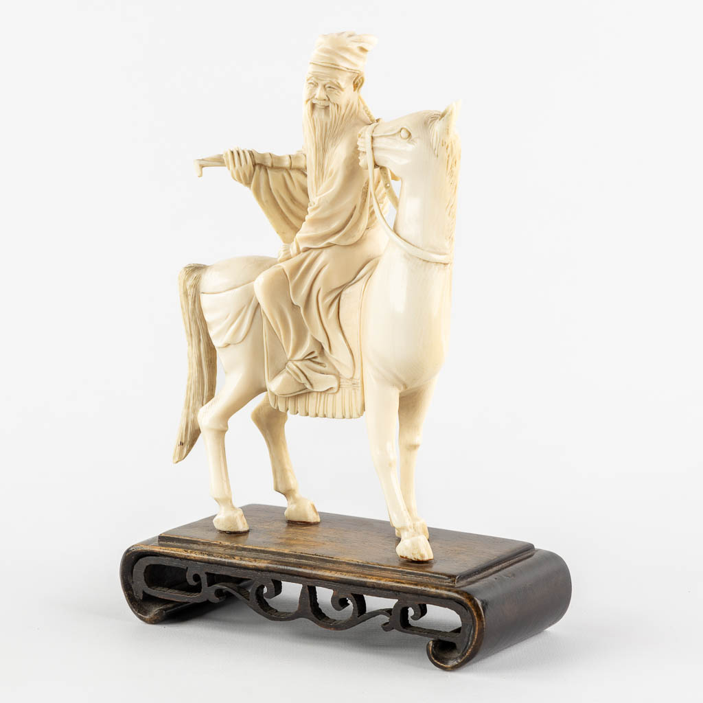 A Chinese sculptured figurine of Zhang Guolao, one of the eight immortals, ivory. (L:6 x W:12 x H:20,5 cm)