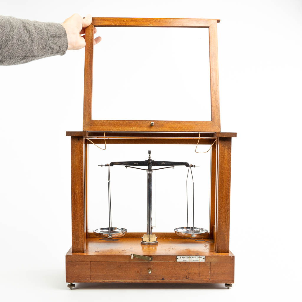 A pharmacy precision scale in a box made of wood and glass and marked A & R Francois Frères, Chatelet Belgique. 