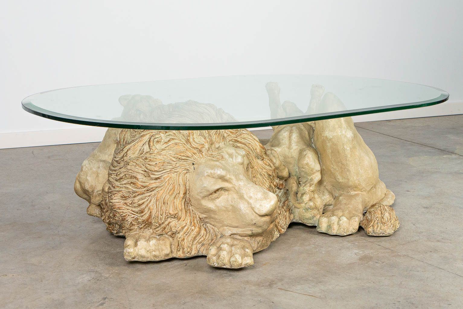 Een salontafel in de vorm van een leeuw met welpen, met glazen tafelblad
