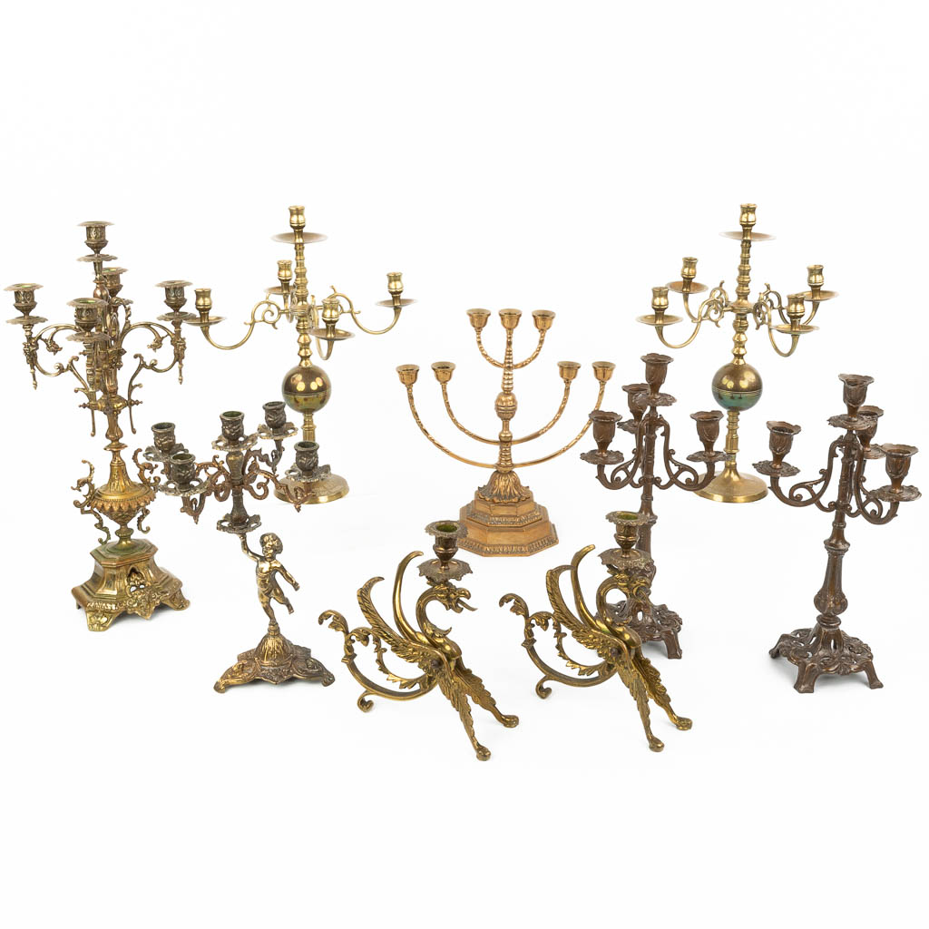 An assembled collection of brass and bronze and spelter candlesticks. (H:56cm)