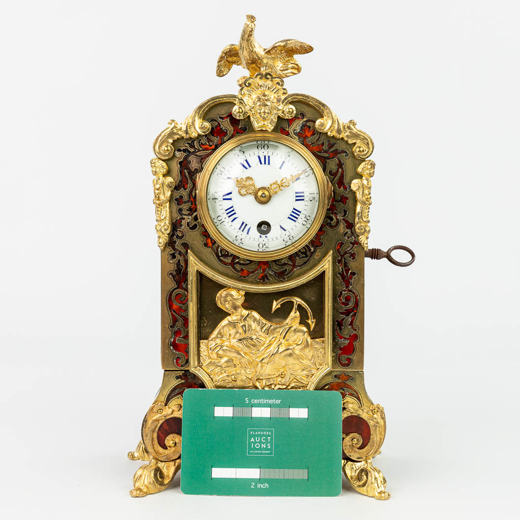 A mantle clock finished with tortoise shell Boulle inlay and mounted with gilt bronze. (H:26cm)