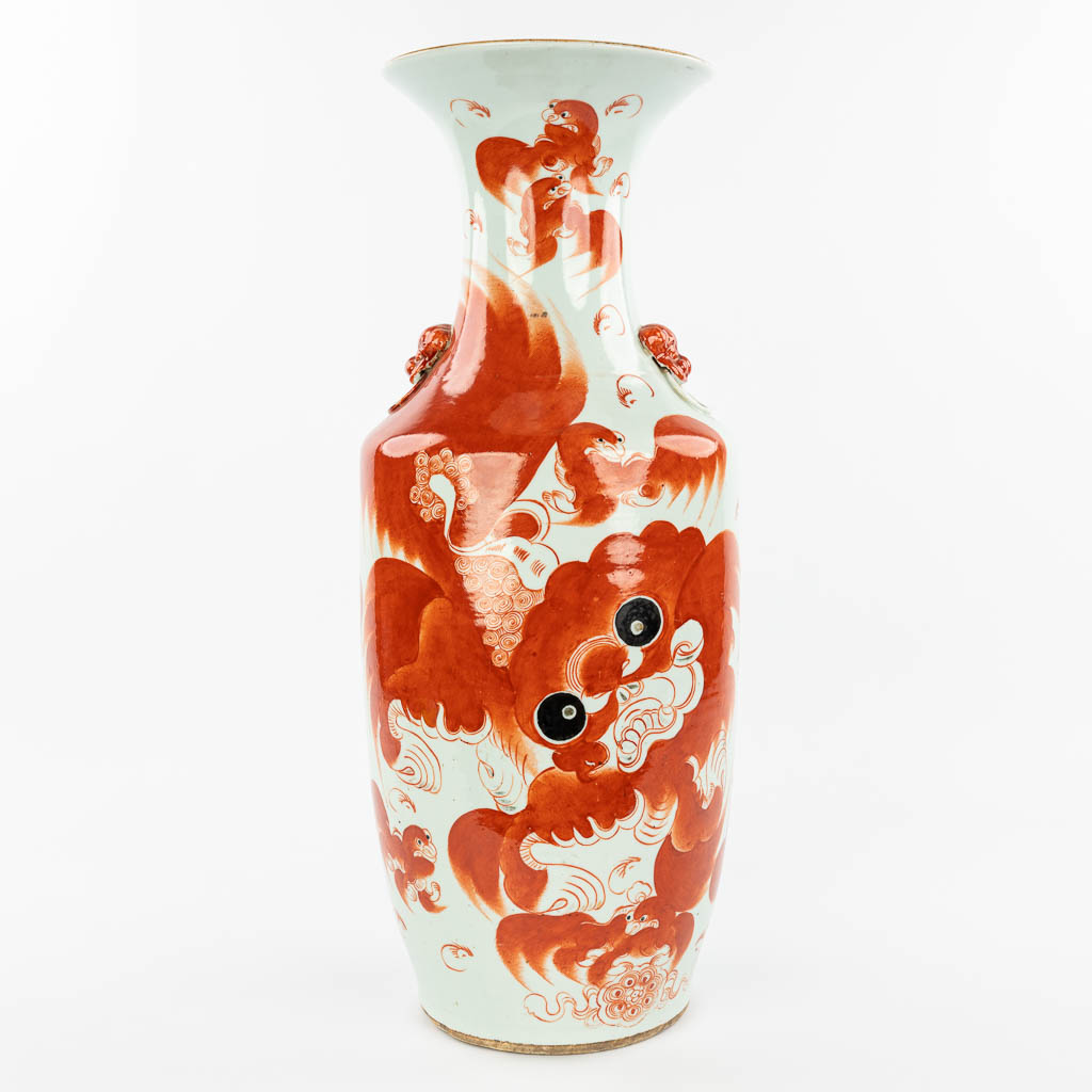 Een Chinese vaas gemaakt uit porselein en versierd met decor van een rode foo hond. (H:59cm)