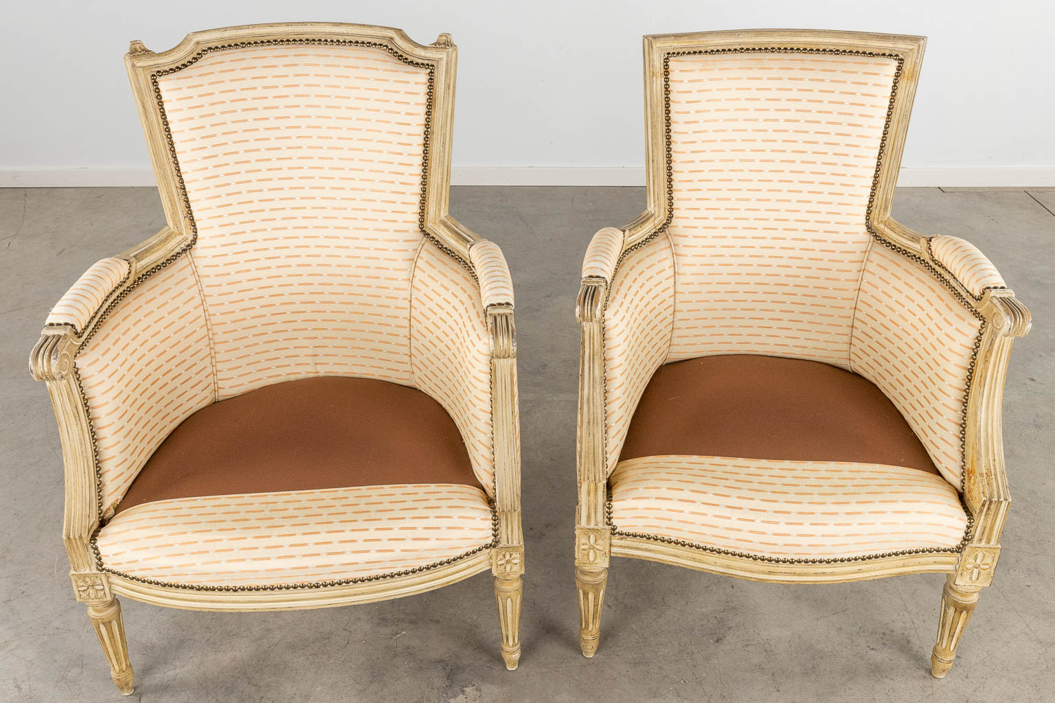A pair of armchairs, sculptured wood with fabric in Louis XVI style. (D:64 x W:66 x H:92 cm)
