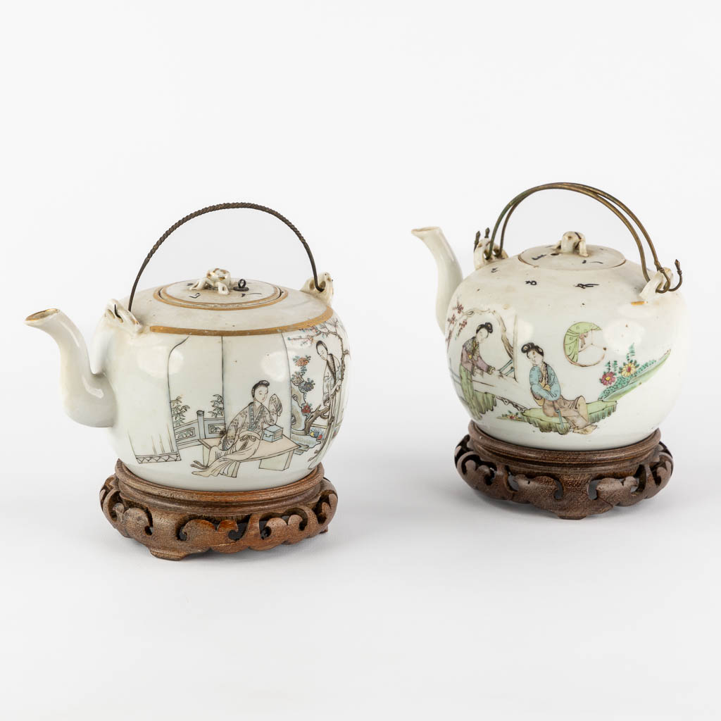 Two Chinese teapots, decorated with figurines. (L:13 x W:17,5 x H:10 cm)