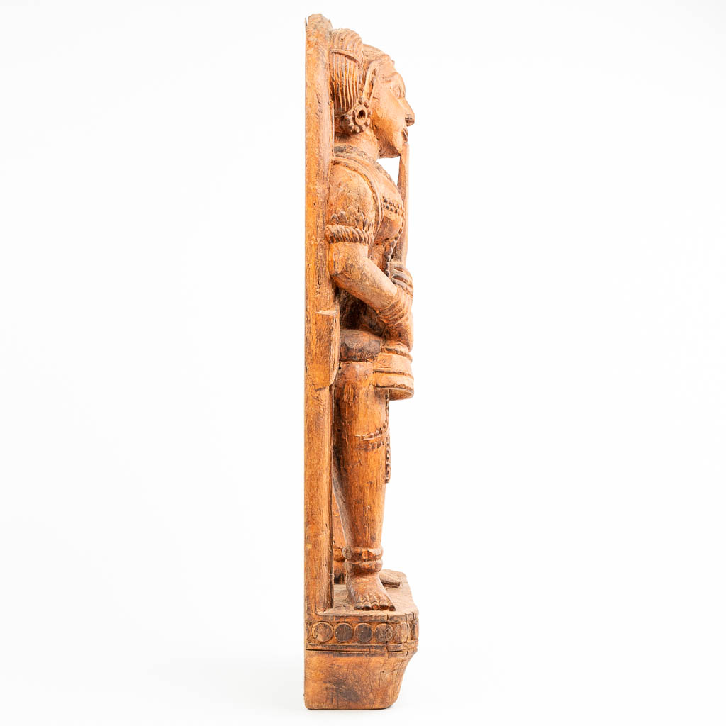 A statue made of sculptured hardwood, probably made in Indonesia. 