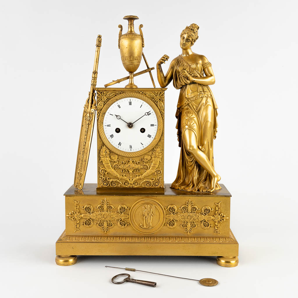 A mantle clock with elegant figurine, ormolu gilt bronze, Empire. 19th C. (D:13 x W:32,5 x H:44 cm)