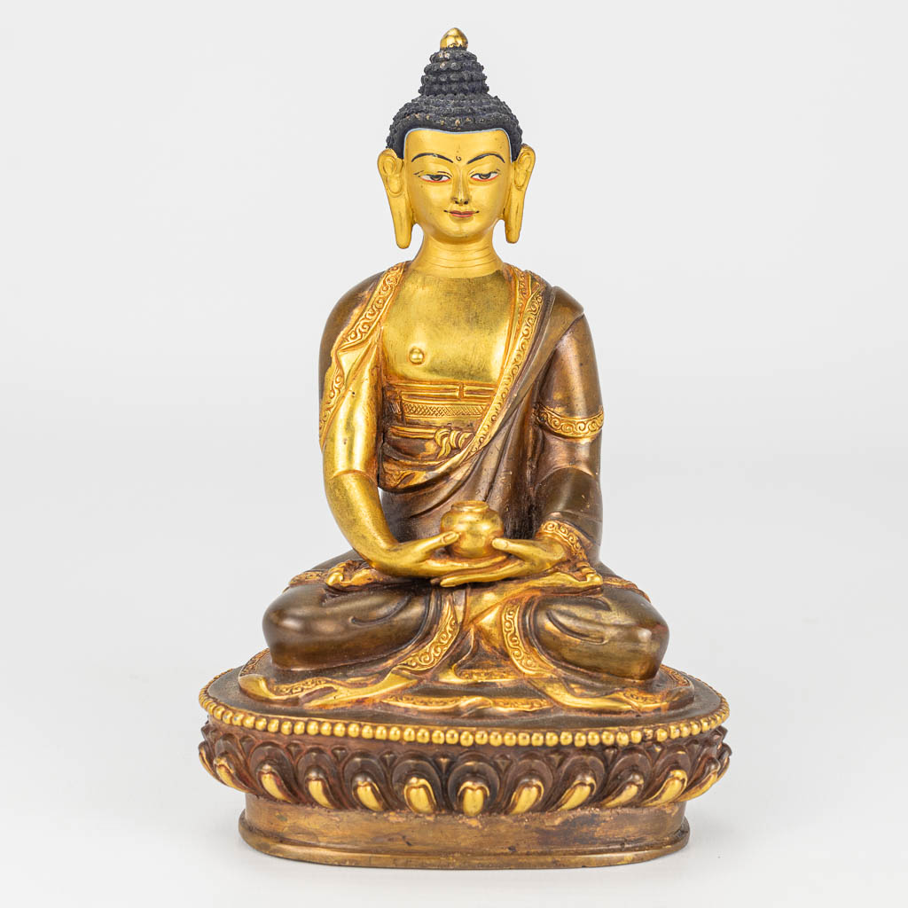 Een bronzen Boeddha met verguld gezicht. 