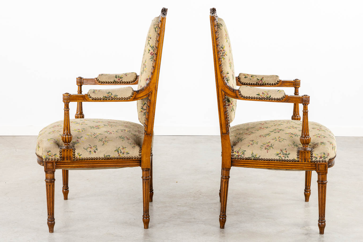 A pair of wood-sculptured armchairs with emboidered upholstry. Louis XVI style. (L:62 x W:64 x H:100 cm)