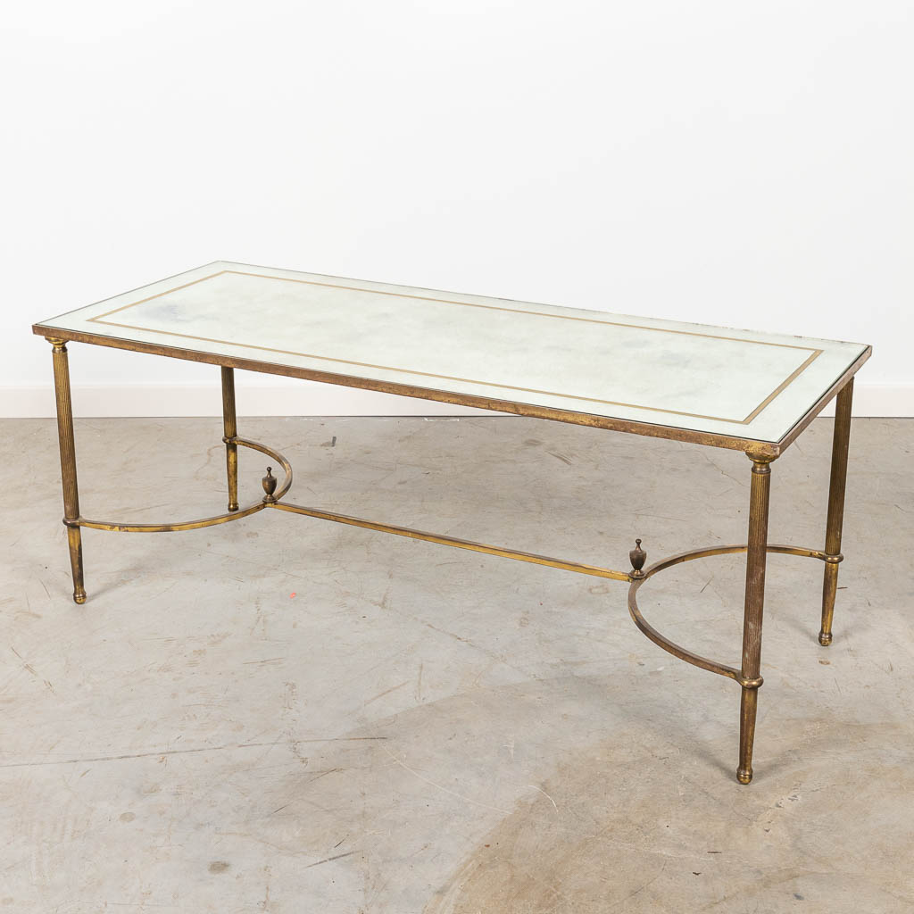 Een mid-century salontafel met spiegelglas en gemaakt uit metaal. 
