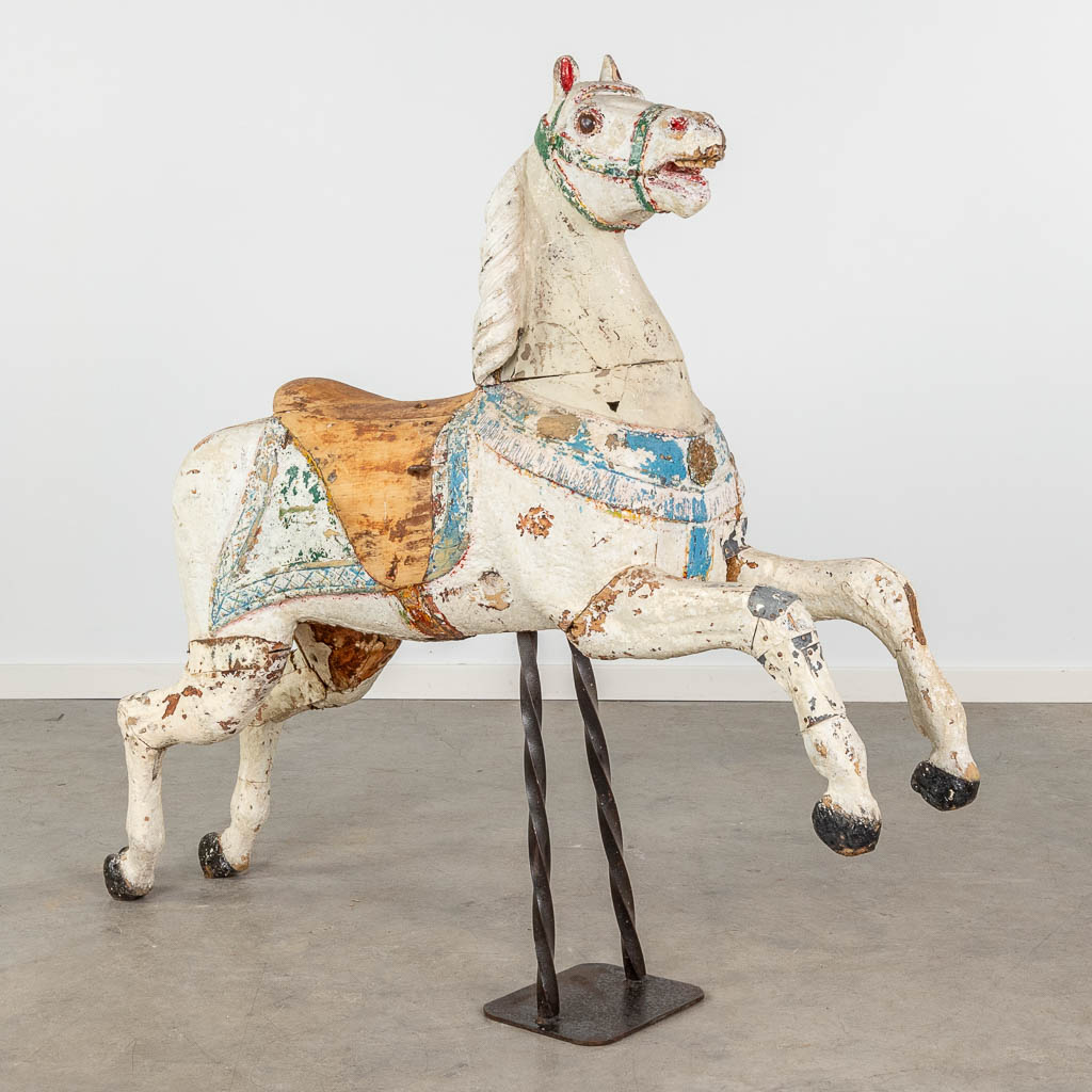 Een antiek kermispaard gemaakt uit gesculpteerd hout met originele polychromie.