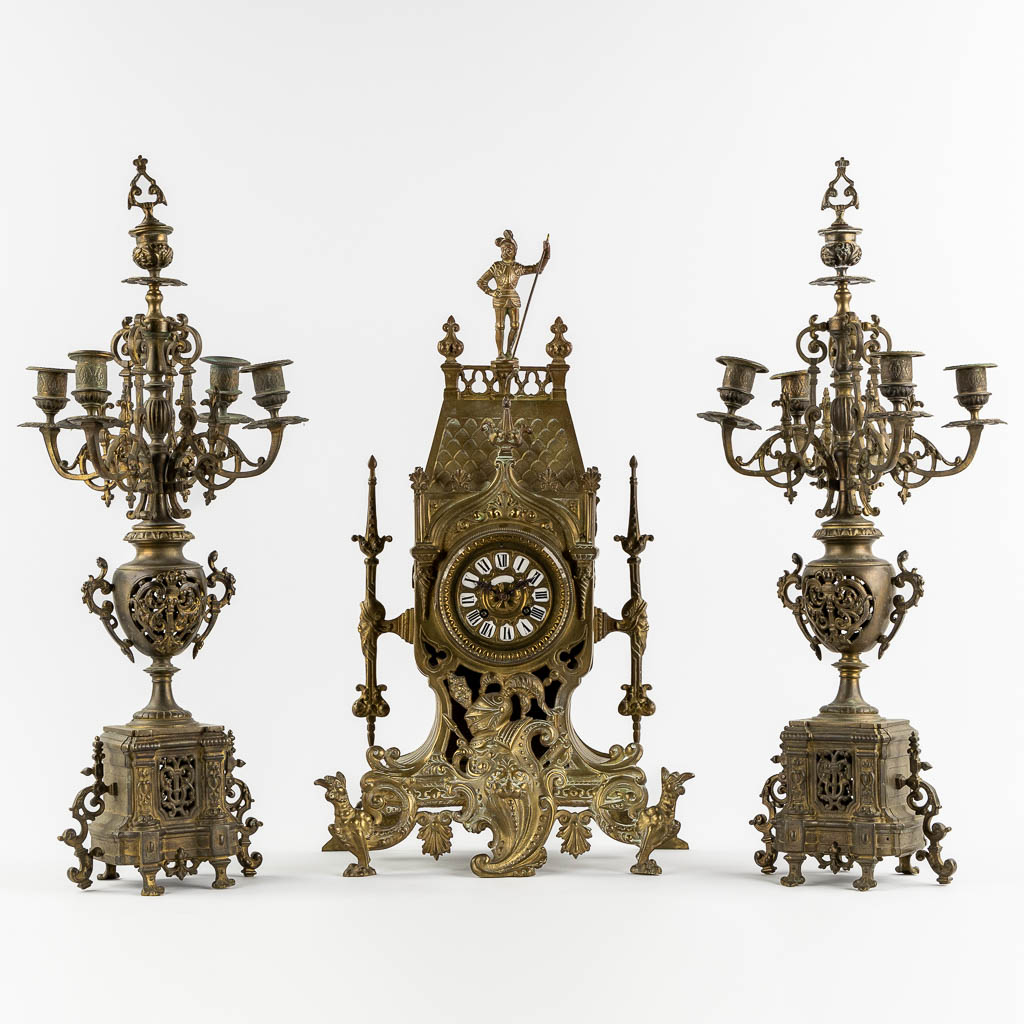 Lot 030 A three-piece mantle garniture in the shape of a castle with a knight, patinated bronze. Circa 1900. (L:18 x W:33 x H:57 cm)