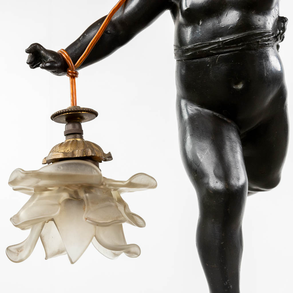 Een halllamp met een figuur van een putto, gepatineerd brons. Circa 1900. (W:34 x H:105 cm)