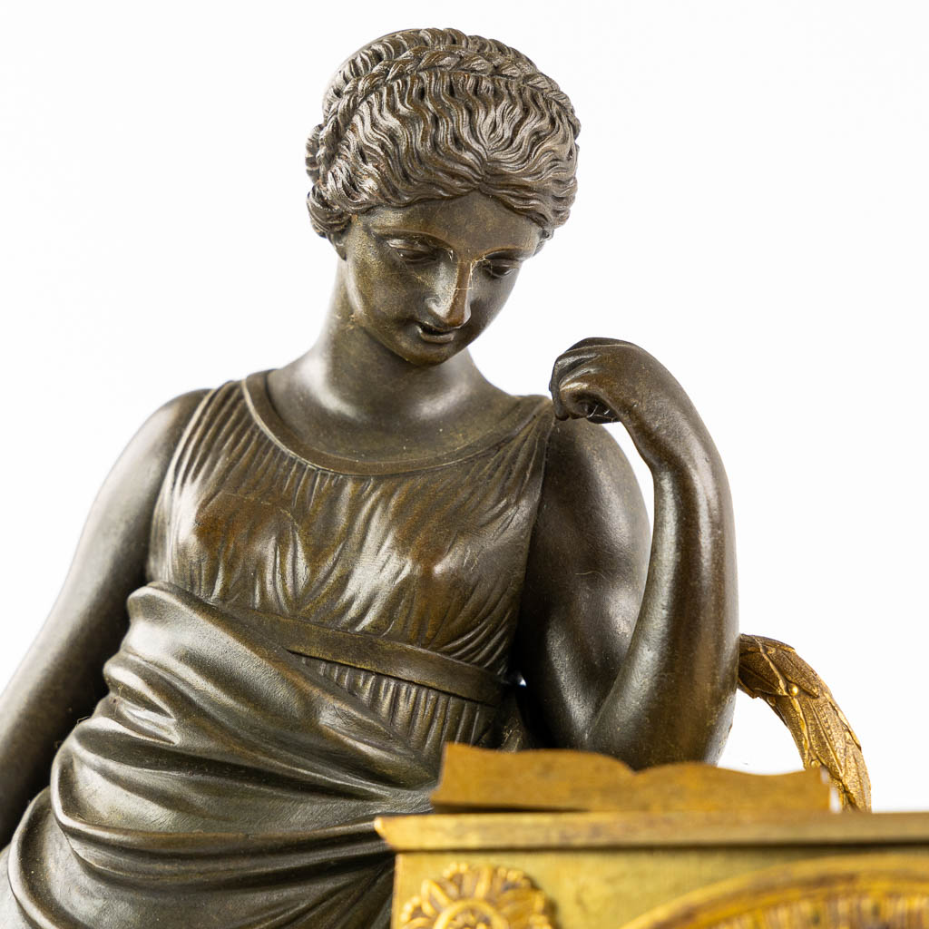 Een schouwklok, verguld brons, Empire. Circa 1800. (L:11,5 x W:26 x H:39,5 cm)
