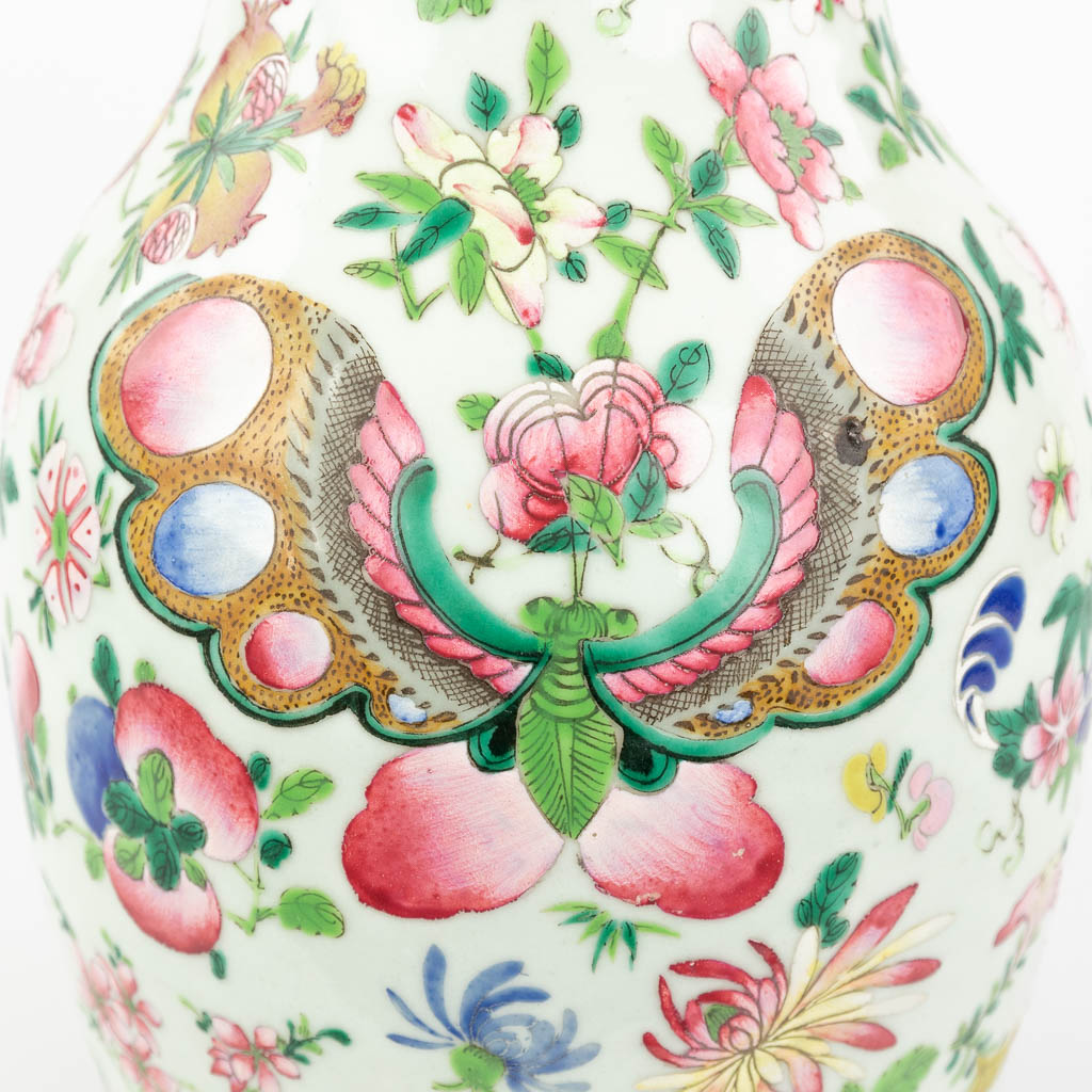 Een Famille Rose Chinese vaas met handgeschilderd decor versierd met bloemen, perziken en vlinders. 19de eeuw. (H: 43 x D: 22 cm