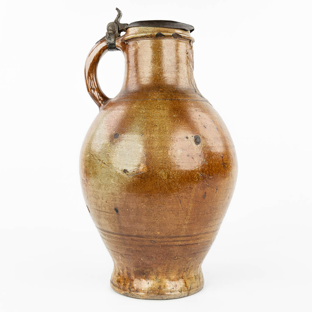 A large and antique Bartmann Jug with lid made of tin. (H:49,5cm)