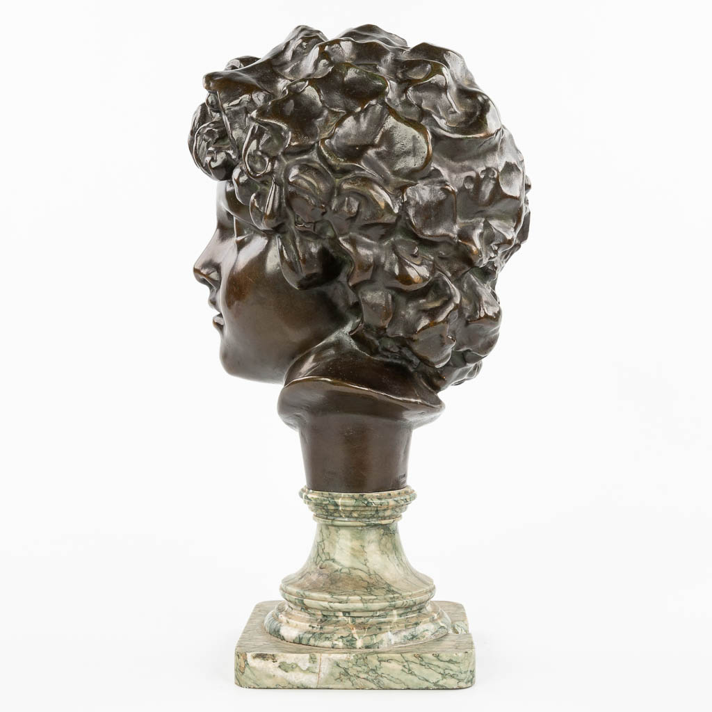 A bronze head of a young man, mounted on a marble base. Marked Peterman, Brussels. (H:40cm)