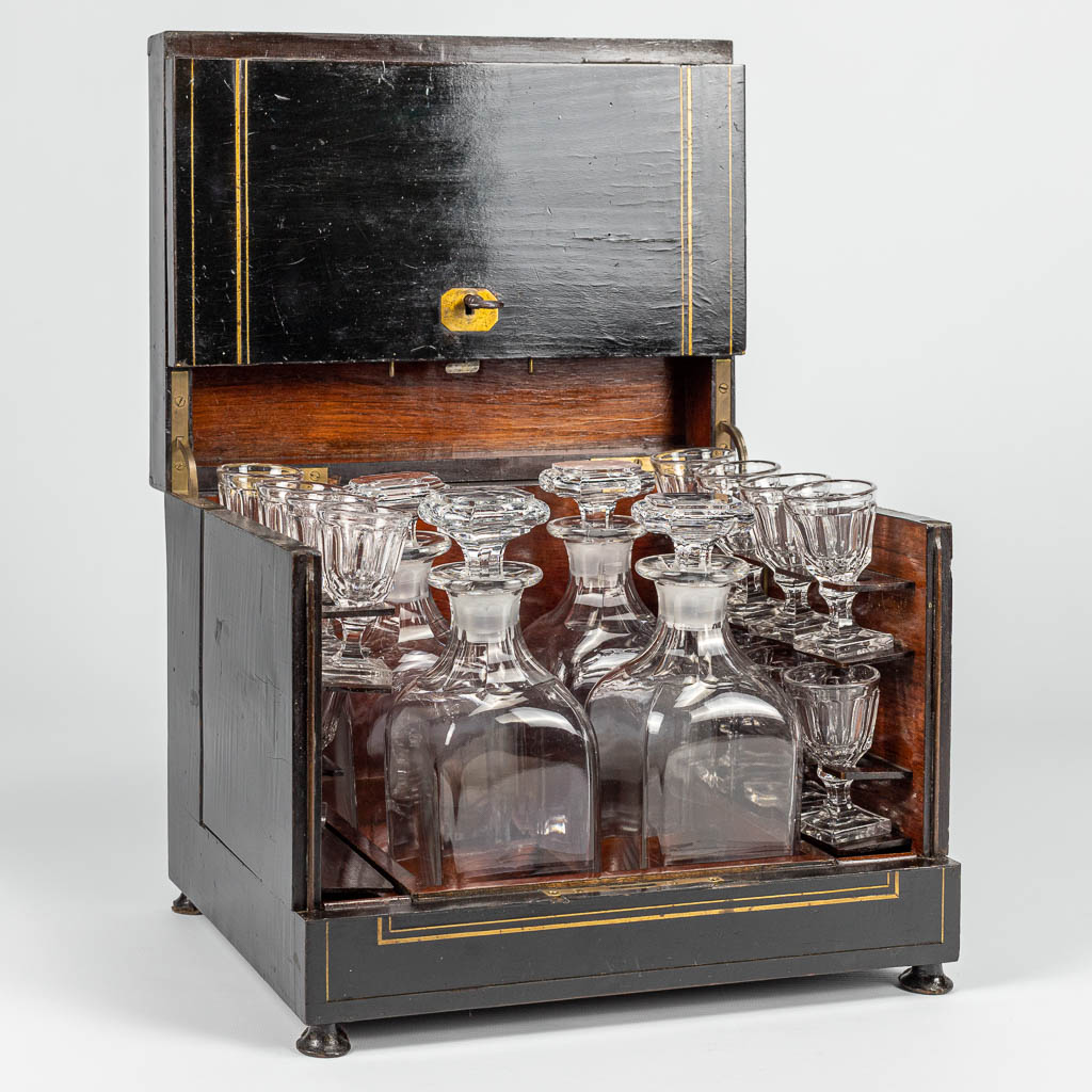 An antique Cave-à-liqueur made of wood with inlaid copper with glasses and caraffes. 