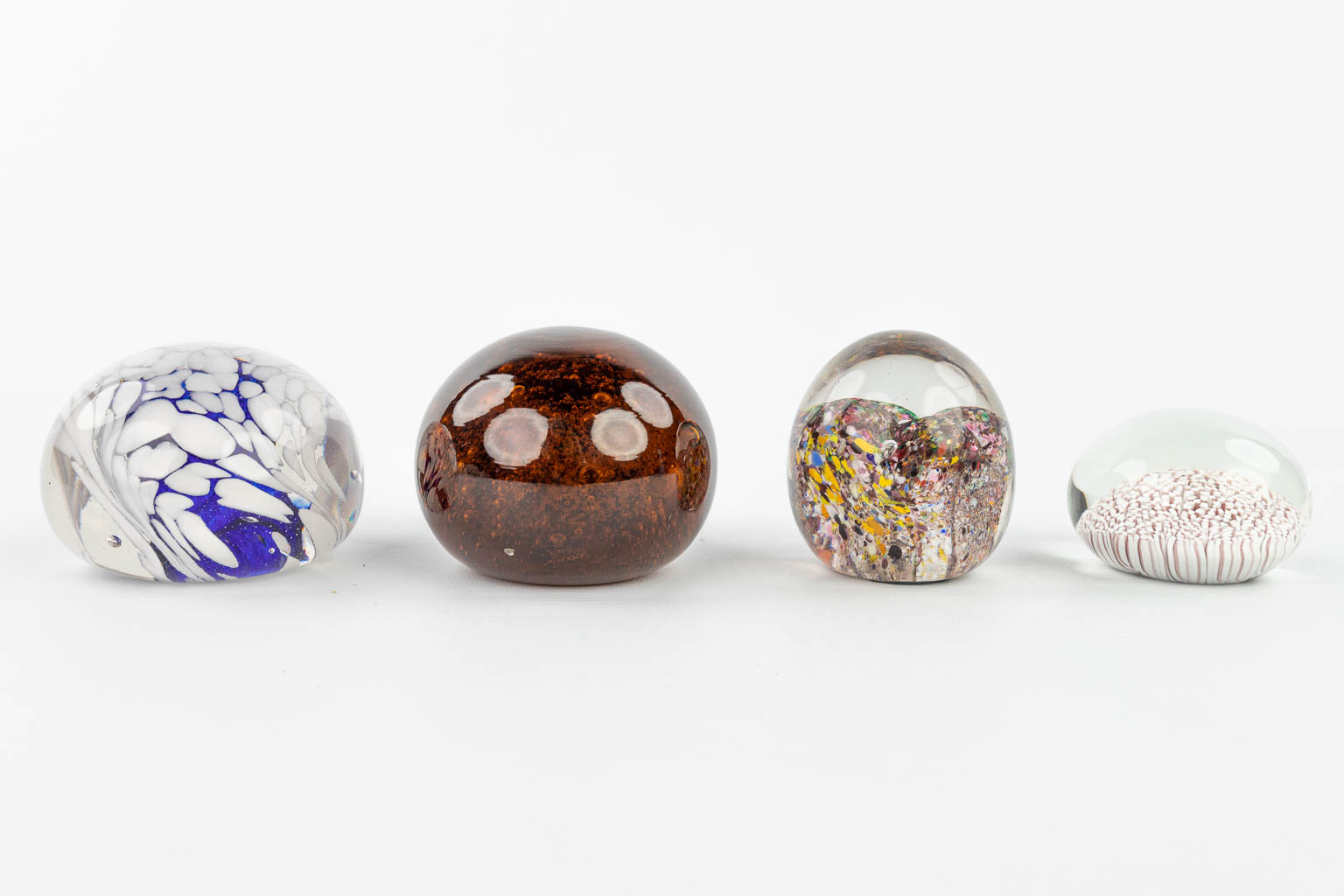 A collection of 7 paperweights made in Murano and decorated with abstract glass art. (H:7,5cm)