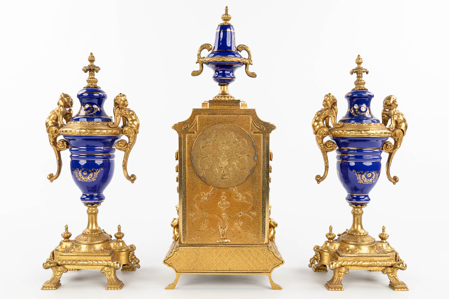 A three-piece mantle garniture clock made of bronze and porcelain and marked Imperial. (H:43cm)