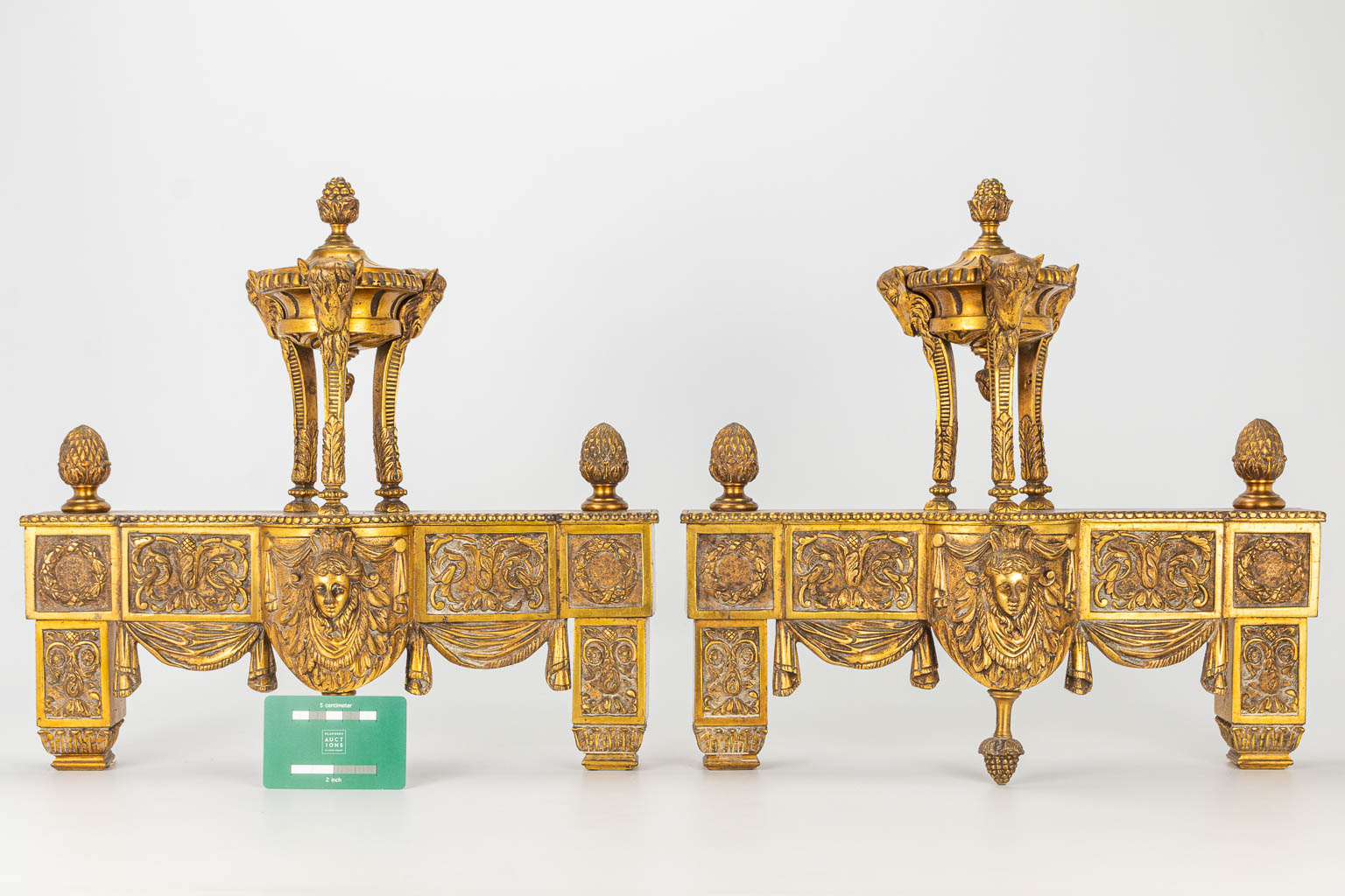 A pair of fireplace andirons made of bronze in Louis XVI style.