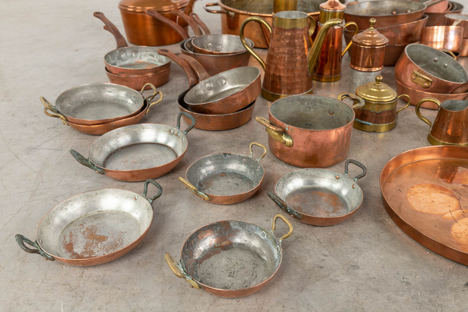 A large collection of copper pots and pans. Approximately 40 pieces. (D:41 x W:49 x H:11 cm)