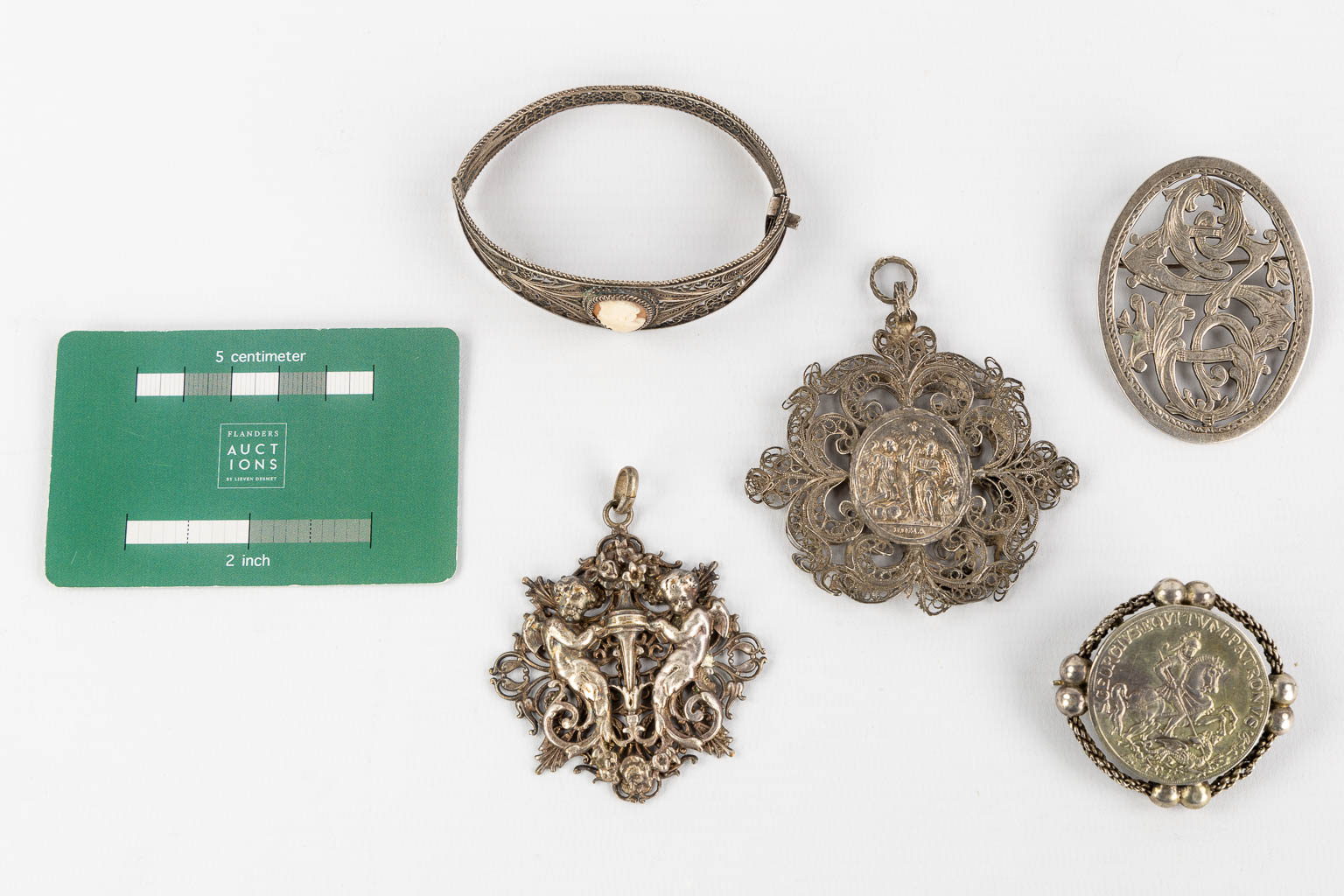 Een collectie zilver hangers, armbanden en broches, Filigraan zilver. 90g. (H:7 cm)