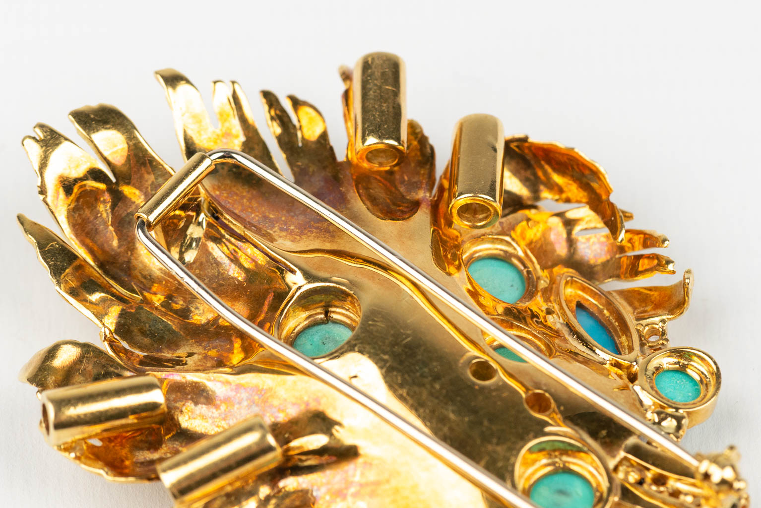 Een grote broche versierd met verschillende soorten edelstenen, halfedelstenen en diamanten in een 18 karaats gouden ontwerp 