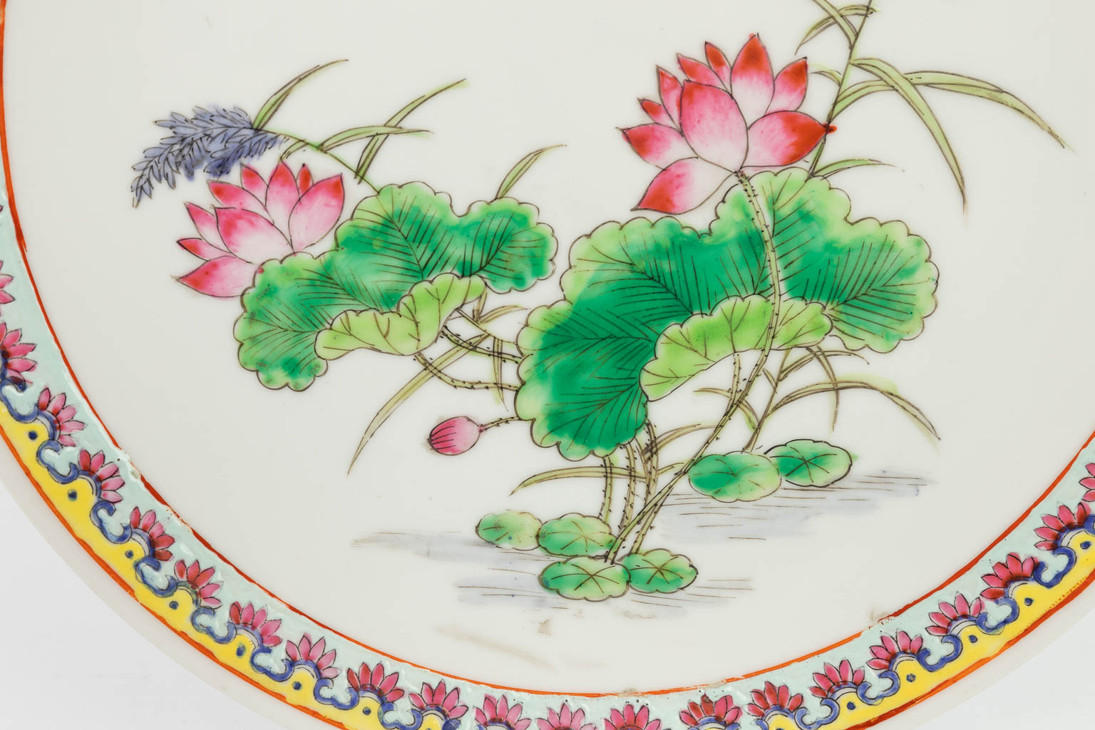A pair of Chinese plates made of porcelain and decorated with fauna and flora. 20th century. Marked Qianlong. 