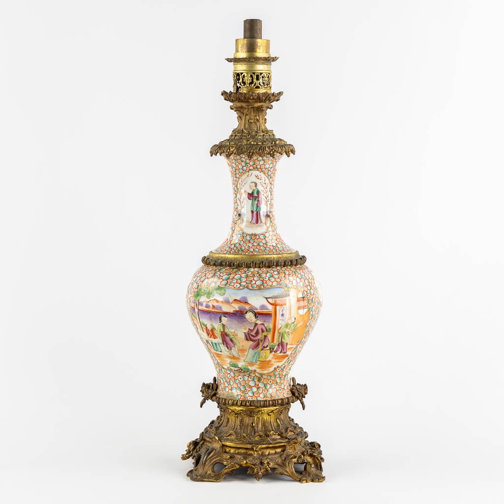 An antique oil lamp, Chinese Famille Rose porcelain mounted with gilt bronze. 19th C. (L:20 x W:20 x H:66 cm)