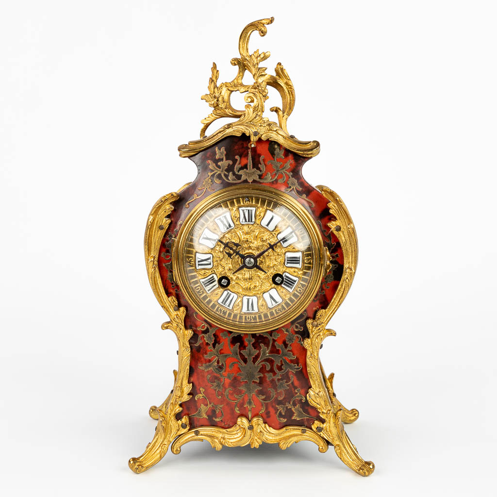 A mantle clock decorated with boulle inlay and mounted with bronze in Louis XV style. (H:33cm)