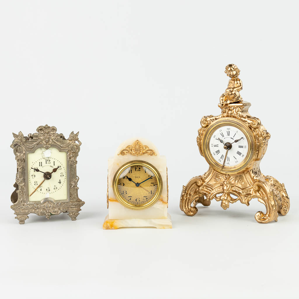 A collection of 3 small table clocks made of bronze, onyx and spelter. (H:21cm)