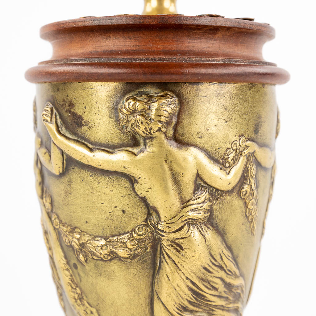 Een antiek bronzen ornament afgewerkt met een Satyr en dame, gemonteerd op perelaar. 19de eeuw. (H: 24 x D: 10 cm)