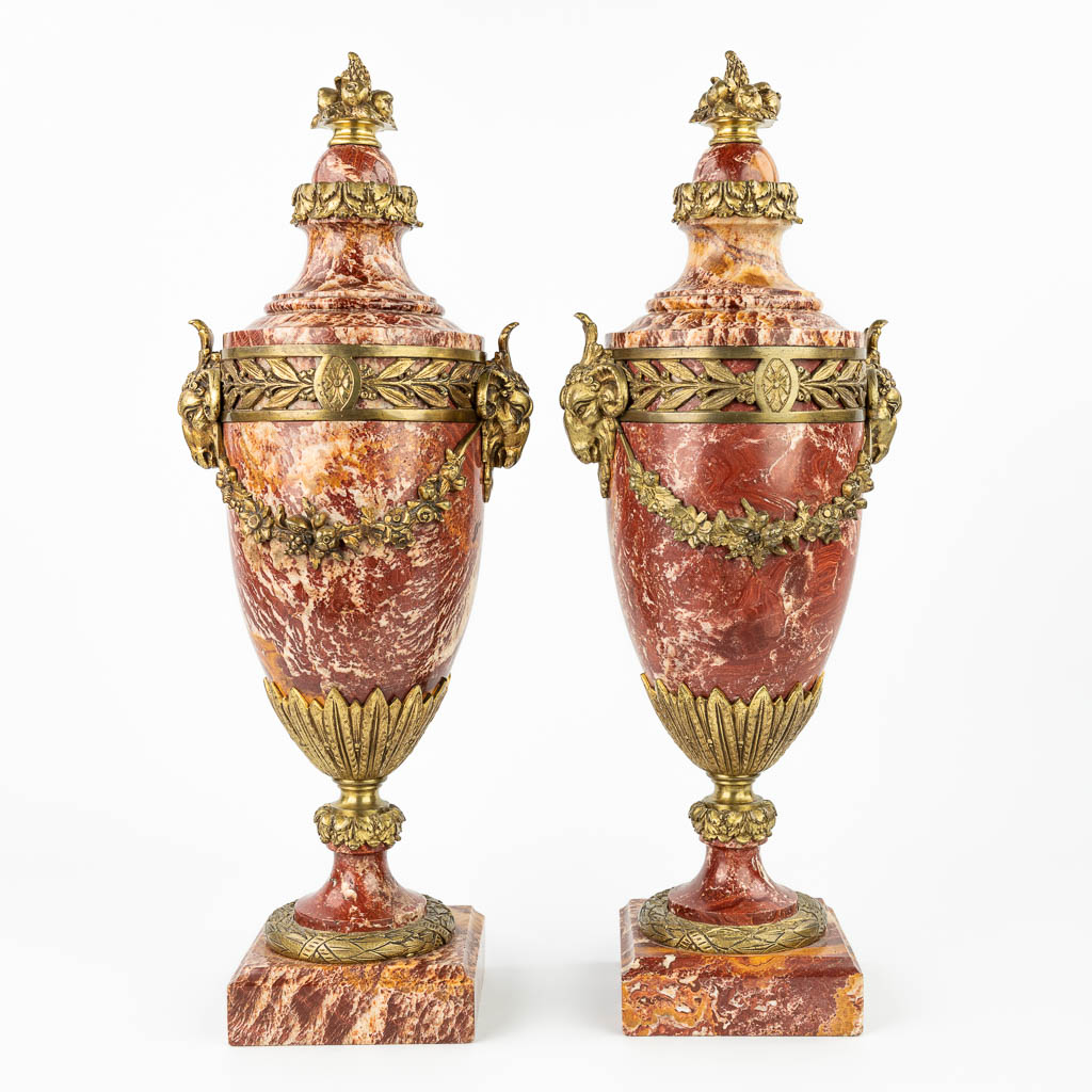 Een paar rood marmeren cassolettes versierd met vergulde bronzen ramskoppen. (H:56cm)