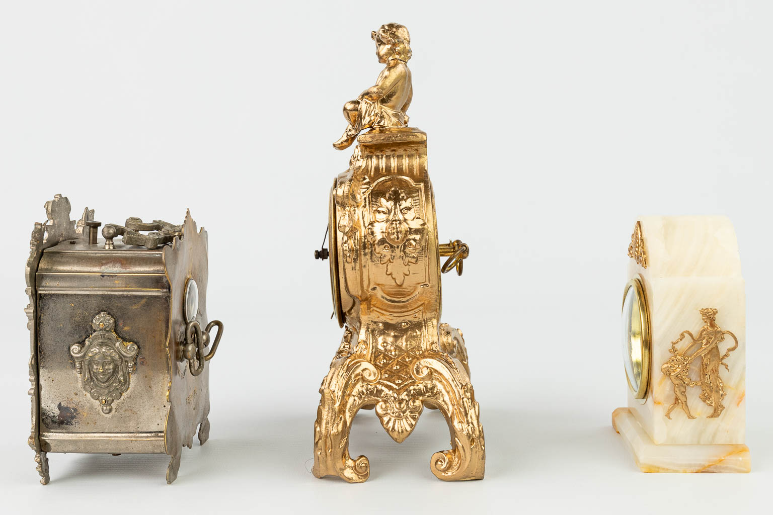 Een collectie van 3 tafelklokjes, gemaakt uit brons, onyx en kunstbrons. (H:21cm)