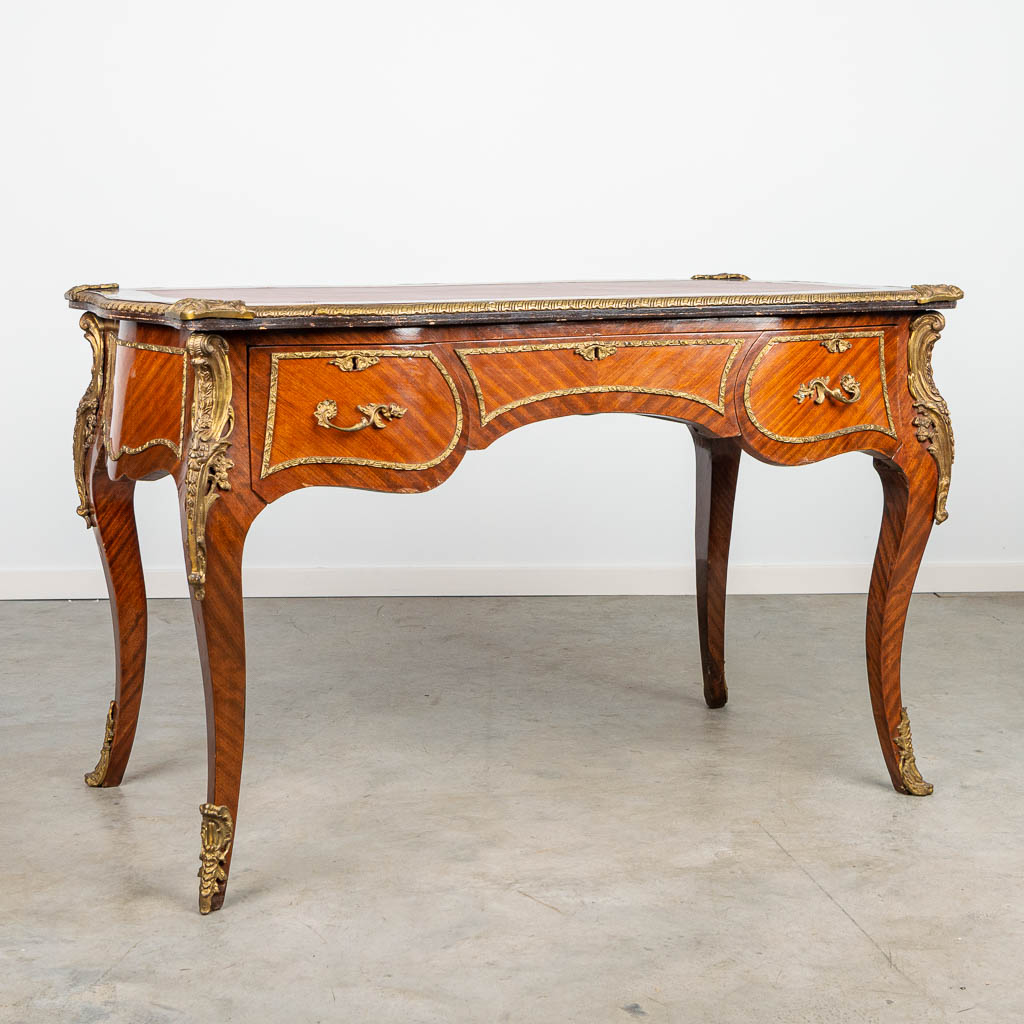 A desk made of wood with veneer and mounted with bronze in Louis XV style.