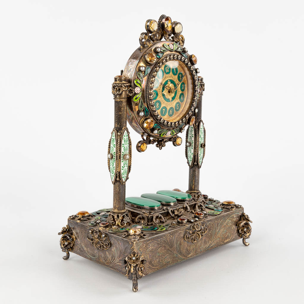 A mantle clock with music box, silver-plated metal and semi-precious stones. Vienna, 20th C. (D:11 x W:16 x H:25 cm)