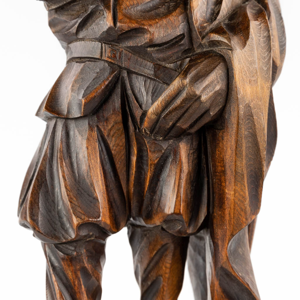 A wood sculpture of a nobleman with a book, circa 1900. (D:15 x W:22 x H:71 cm)