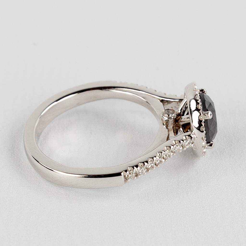 A ring, 18kt white gold with a black diamond, appr. 1.62ct and smaller brilliants, appr. 0.32ct. Ring size: 56.