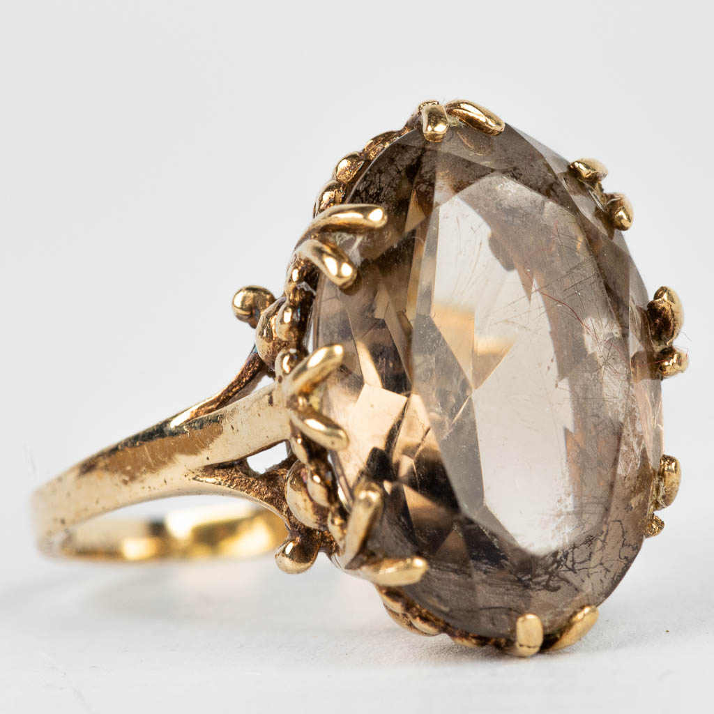 A ring with brown natural stone in a ring made of 9 karat yellow gold. 