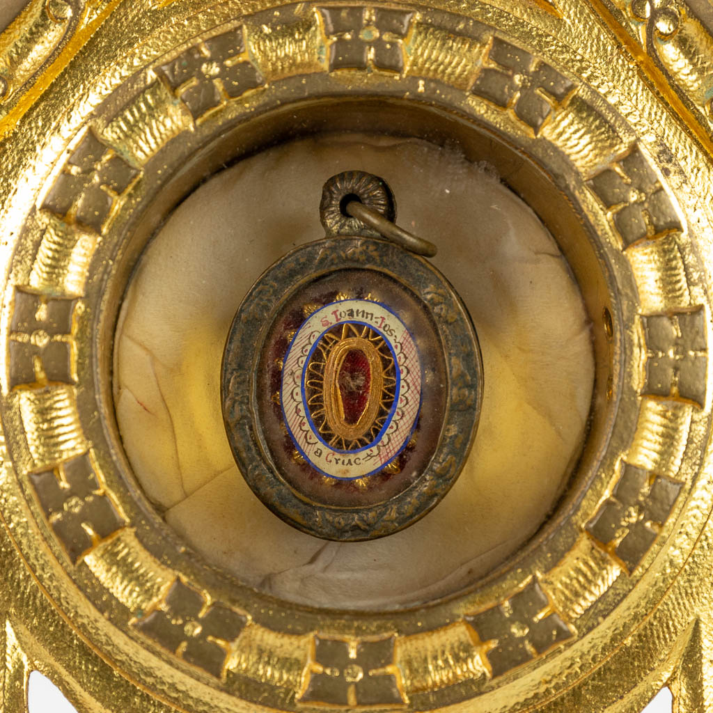 A sealed Theca with a relic: Joannis a Cruce, mounted in a brass monstrance. (D:11,5 x W:13 x H:35 cm)