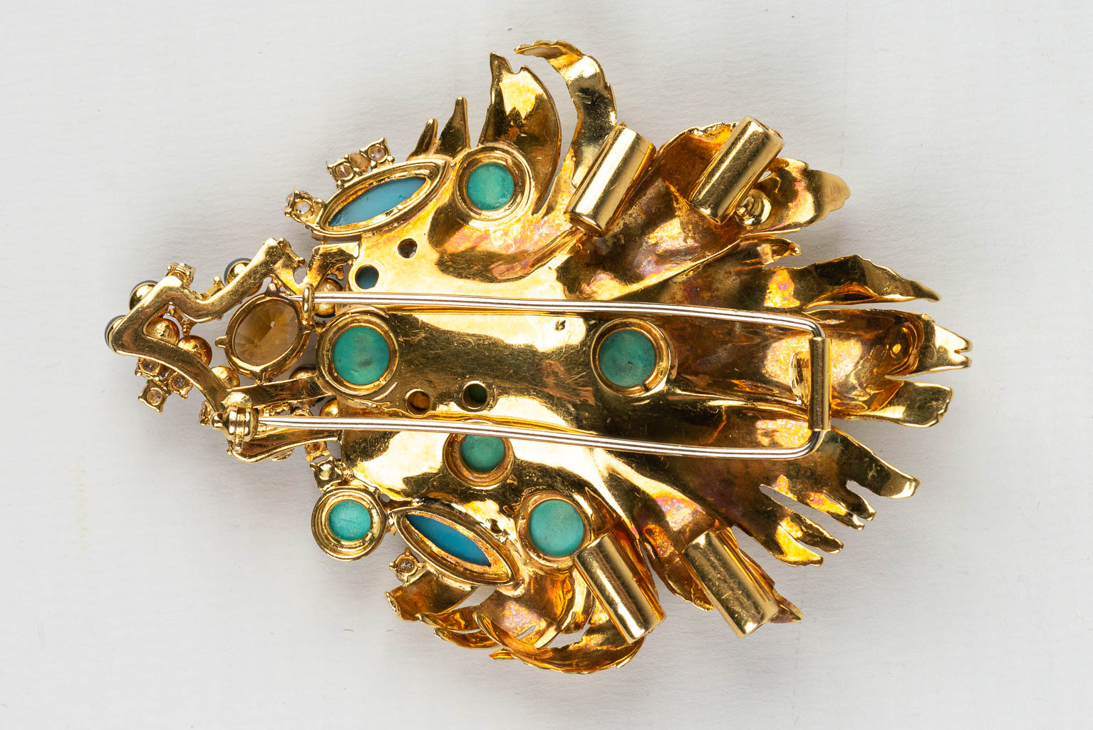 Een grote broche versierd met verschillende soorten edelstenen, halfedelstenen en diamanten in een 18 karaats gouden ontwerp 