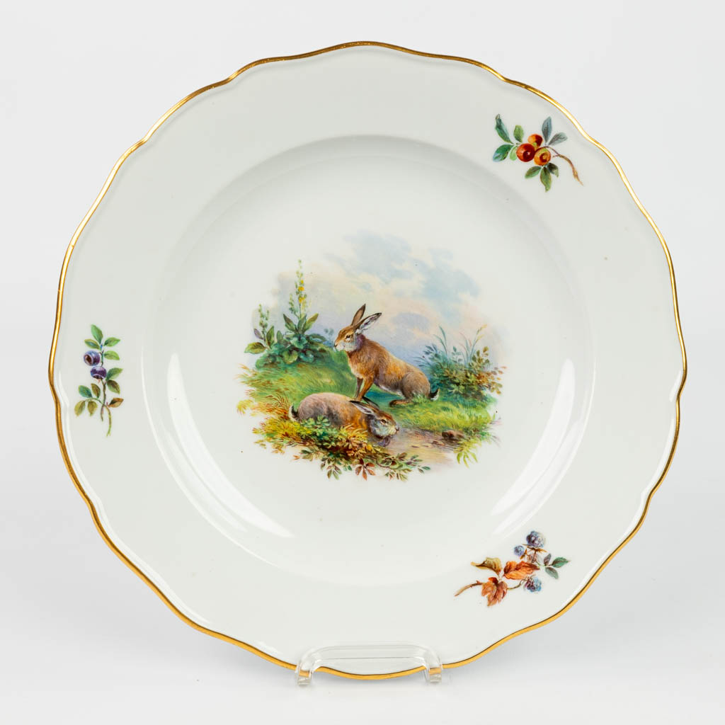 A set of 8 plates with hand-painted images of wild animals and marked with crossed swords, marked Meissen. 