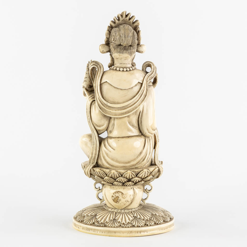 A Chinese Buddha holding a Ruyi and Buddha, sculptured ivory. Circa 1900. (L:10,5 x W:12,5 x H:25,5 cm)