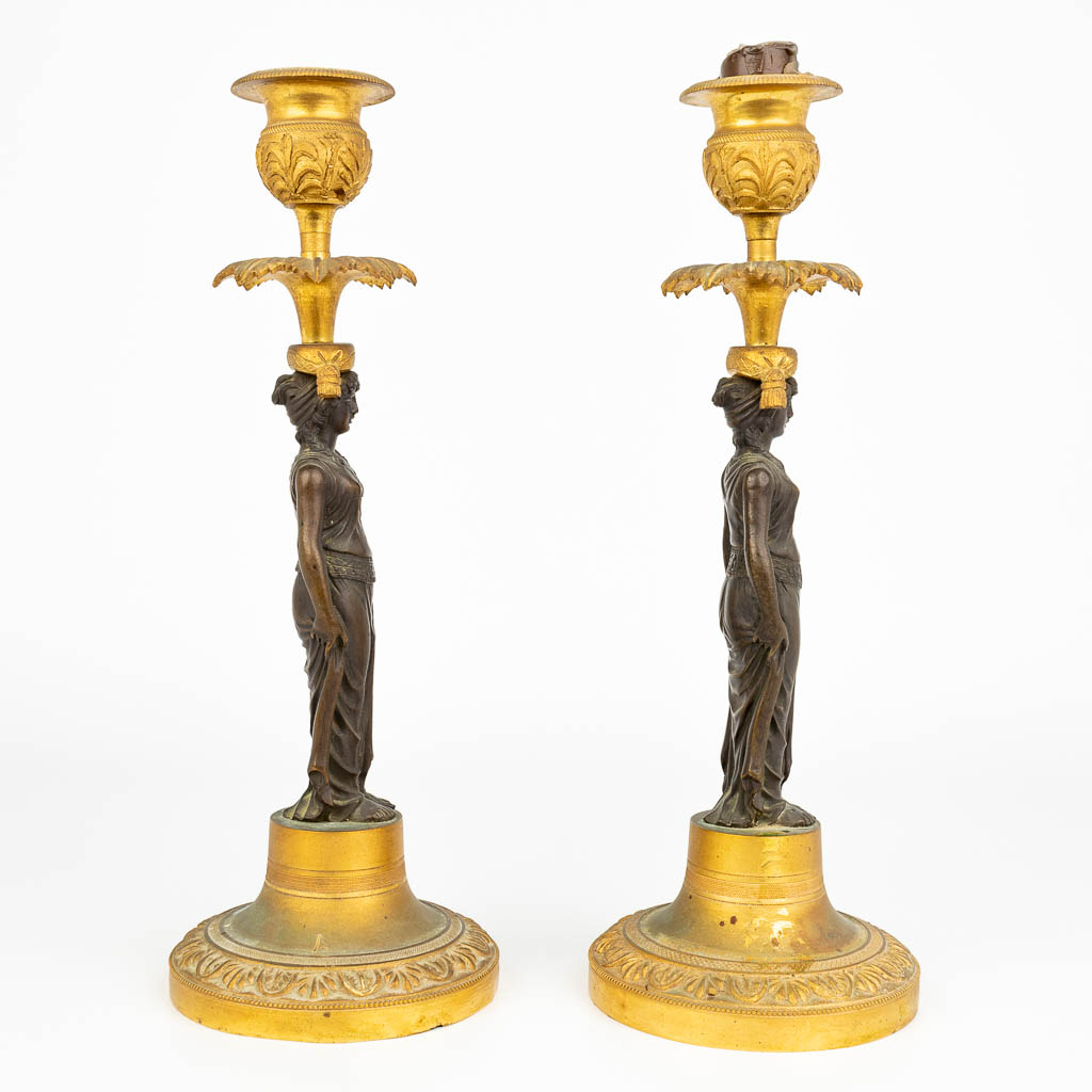 A pair of caryatid candlesticks, made of patinated and ormolu bronze during the empire period, early 19th century. (H:27cm)