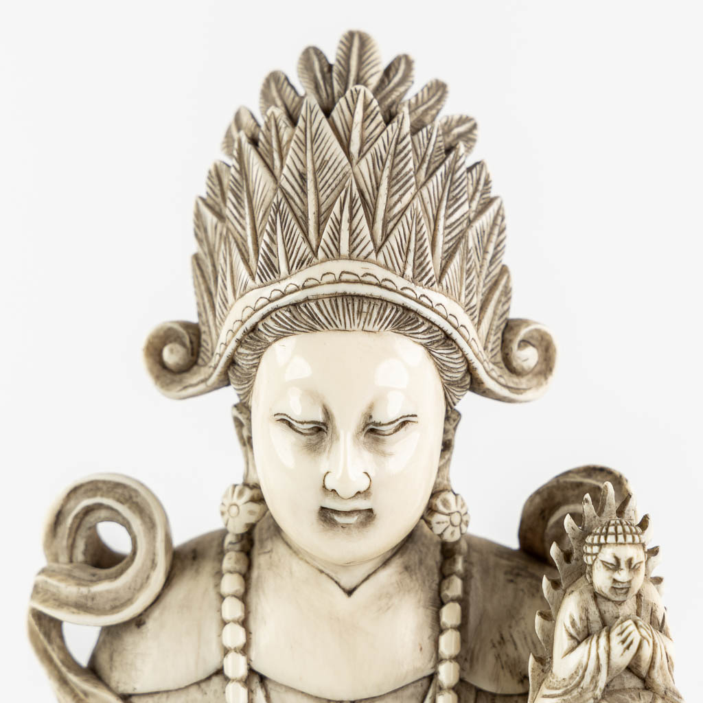 A Chinese Buddha holding a Ruyi and Buddha, sculptured ivory. Circa 1900. (L:10,5 x W:12,5 x H:25,5 cm)