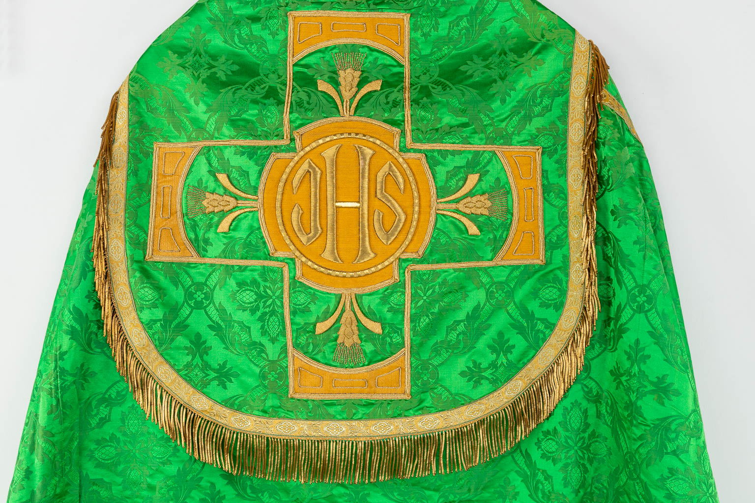 Een Koorkap en Schoudervelum, afgewerkt met IHS logo en dik goudbrokaat op groene stof. 