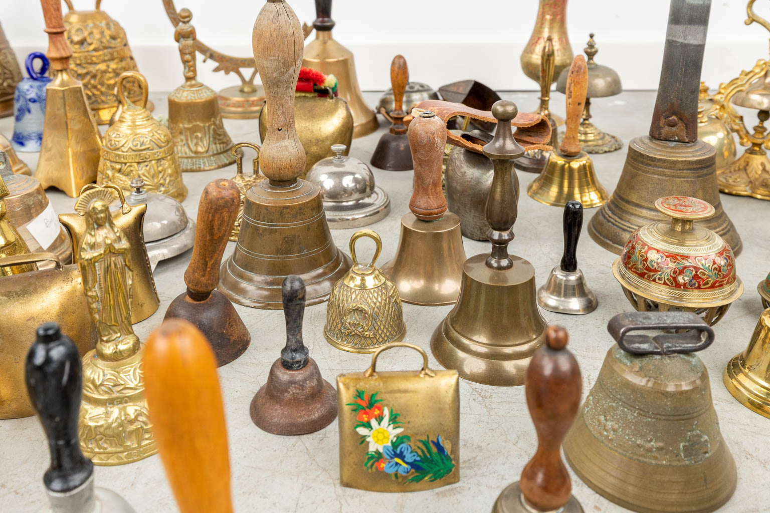 A large collection of table bells made of bronze and metal. 