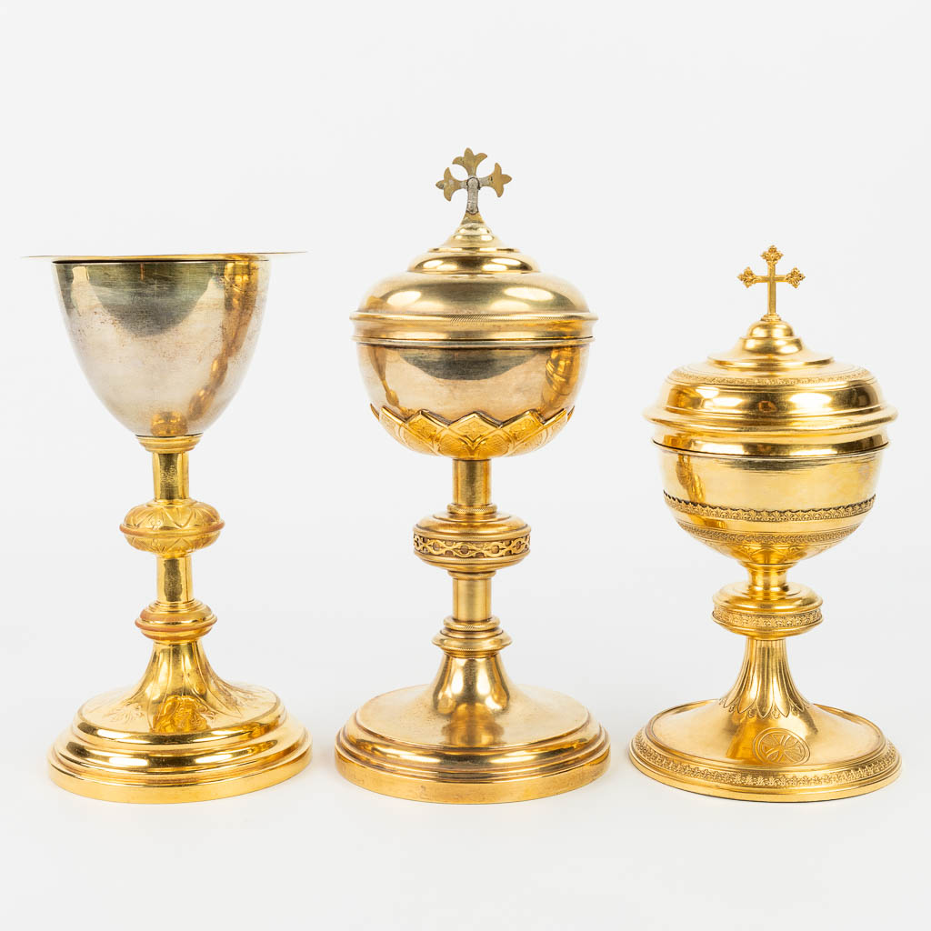 A collection of 4 large ciboria and a chalice made of silver and gold plated metal. 