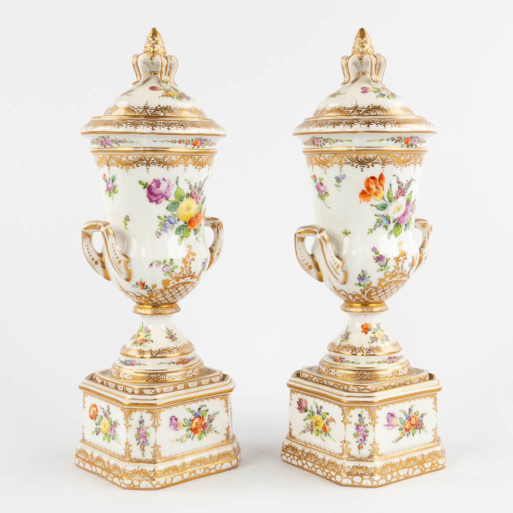 Dresden, a pair of polychrome urns with a lid. Hand-painted floral decor. (L:8,5 x W:9 x H:26 cm)