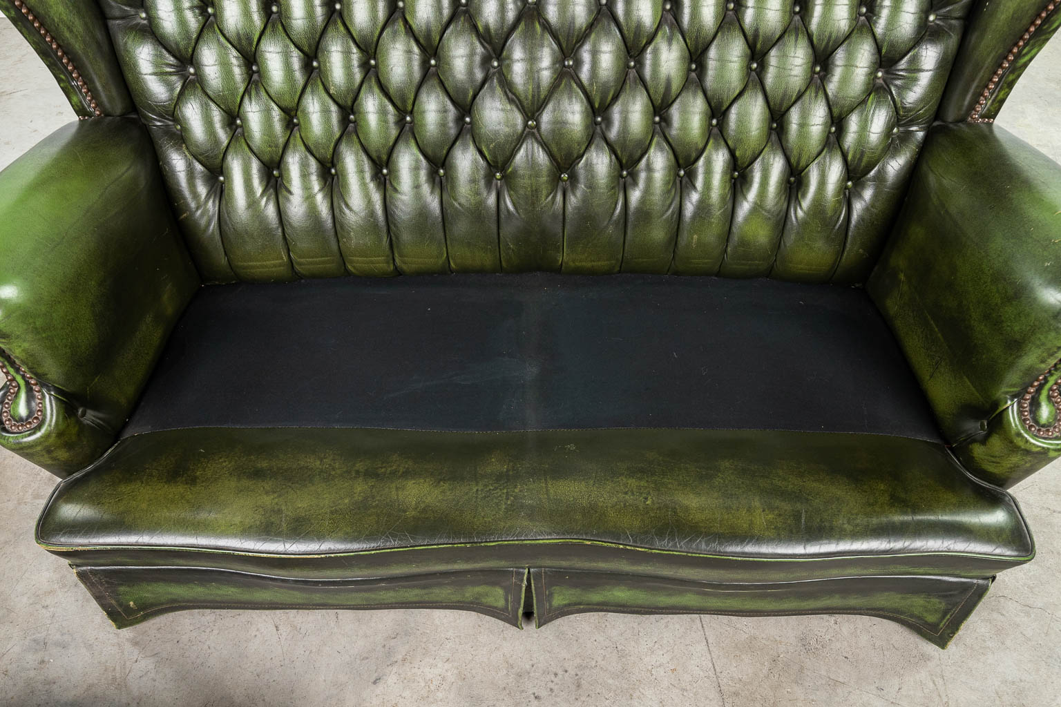 A green leather armchair with high back made in Chesterfield style. (H:107cm)